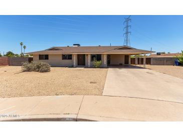Single story home featuring a large covered carport and desert landscaping at 1351 E Ellis Cir, Mesa, AZ 85203