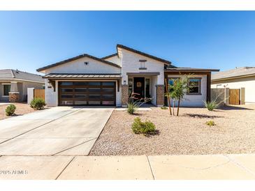 Charming single-story home featuring a modern garage door, low-maintenance landscaping, and neutral color palette at 1360 E Avenida Kino --, Casa Grande, AZ 85122
