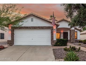 Charming home featuring stone accents, white stucco and a two-car garage, and desert landscaping at 2108 E Patrick Ln, Phoenix, AZ 85024