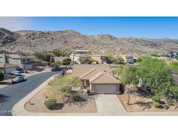 Charming one-story home with a two-car garage and desert landscaping against a mountain backdrop at 3441 E Melody Dr, Phoenix, AZ 85042