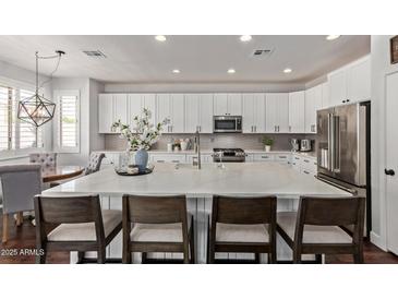 Bright kitchen featuring a spacious island, white cabinets, and stainless steel appliances at 1342 E Jade Dr, Chandler, AZ 85286