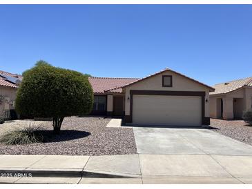Charming single-story home with a well-maintained front yard and a two-car garage at 15731 W Evans Dr, Surprise, AZ 85379