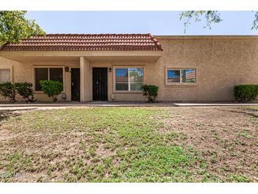 Beige, single-story home with red tile roof and desert landscaping in a sunny setting at 17228 N 16Th Dr # 3, Phoenix, AZ 85023