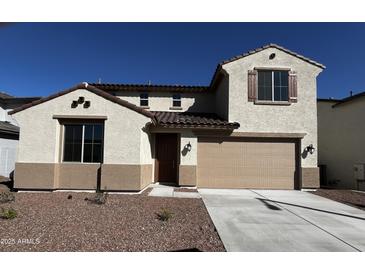 Two-story home featuring a two-car garage, stucco siding, and a tile roof, under a bright blue sky at 17535 W Fulton St, Goodyear, AZ 85338