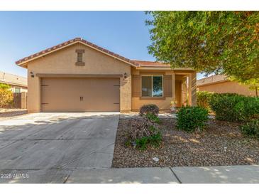 Charming single-story home featuring a neutral-toned exterior, a two-car garage, and low maintenance landscaping at 40027 W Pryor Ln, Maricopa, AZ 85138
