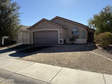 Charming single-story home featuring a two-car garage and desert landscaping at 45499 W Sky Ln, Maricopa, AZ 85139
