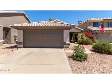 Charming home featuring a well-kept yard with a spacious driveway and an attached two-car garage at 5018 W Wikieup Ln, Glendale, AZ 85308