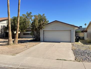 Attached one-car garage with a concrete driveway and desert landscaping in the front yard at 8114 E Jackrabbit Rd, Scottsdale, AZ 85250
