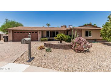 Charming single-story home with a well-maintained xeriscaped front yard and brick accents at 8620 E Sells Dr, Scottsdale, AZ 85251