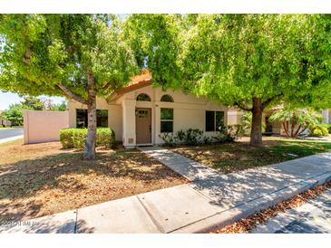 Charming single-story home featuring mature trees, neutral stucco, and a welcoming front entrance at 967 E Hearne Way, Gilbert, AZ 85234