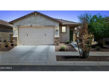 Charming single-story home showcasing a well-maintained front yard, a two-car garage, and desert landscaping at 14360 W Pershing St, Surprise, AZ 85379