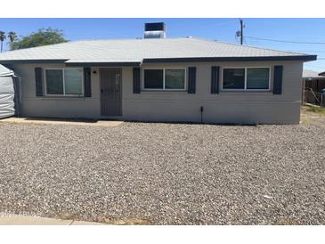 Charming single-story home with light grey exterior, black shutters, and xeriscaped front yard for low maintenance at 2431 W Seldon Ln, Phoenix, AZ 85021