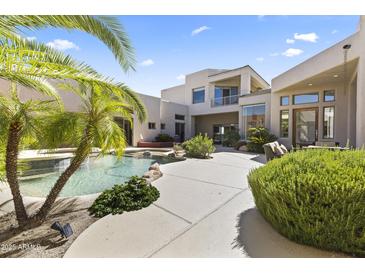 Stunning backyard pool area, complete with lush landscaping and a cozy outdoor seating area at 28729 N 107Th St, Scottsdale, AZ 85262