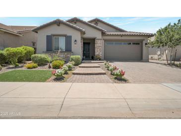 Charming home featuring a stone facade, paved driveway, and well-maintained landscaping at 41215 W Almira Dr, Maricopa, AZ 85138