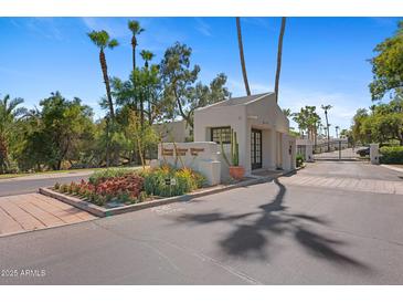 A beautiful desert landscape and palm trees surround the entrance to Scottsdale House Condominiums at 6138 N 28Th St, Phoenix, AZ 85016