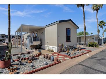 Inviting manufactured home featuring desert landscaping, covered parking, and a charming, well-maintained exterior at 8421 E Main St # 116, Mesa, AZ 85207