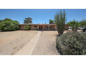 Charming single-story brick home featuring a spacious front yard and mature desert landscaping at 6249 E Larkspur Dr, Scottsdale, AZ 85254