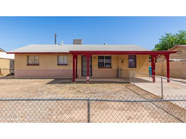 Cozy single-story home featuring a covered porch and a low, chain-link fence around the front yard at 6521 W Flower St, Phoenix, AZ 85033