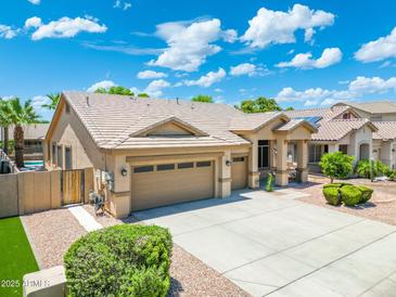 Charming home featuring a three-car garage, desert landscaping, and a refreshing private pool at 6967 W Irma Ln, Glendale, AZ 85308