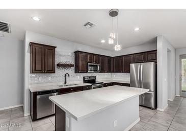 Modern kitchen with stainless steel appliances, dark wood cabinetry, and a large island at 7423 S 28Th Pl, Phoenix, AZ 85042