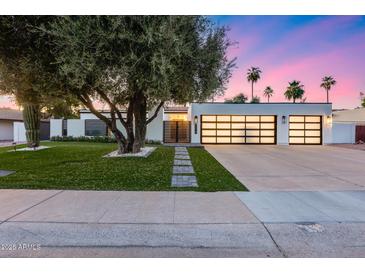 Charming single-story home with a modern design, lush lawn and three car garage at 8618 E Via De Encanto --, Scottsdale, AZ 85258