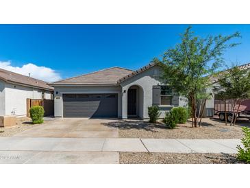 Charming single-story home featuring a well-manicured lawn, neutral paint, and a two-car garage at 14338 W Bronco Trl, Surprise, AZ 85387