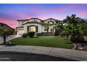 Elegant two-story home with a lush green lawn, palm trees, and a charming facade at 1755 E Tonto Dr, Chandler, AZ 85249