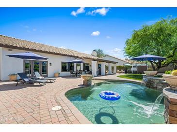 Inviting backyard pool with waterfall feature and lounge seating, perfect for relaxation and outdoor entertaining at 4507 E Duane Ln, Cave Creek, AZ 85331