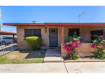 Charming single-story home with brick facade, flowering bushes, and a covered entry, showcasing curb appeal at 6739 N 16Th St # 14, Phoenix, AZ 85016