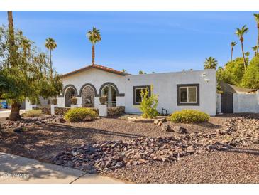 Charming home features a rock garden and lovely desert landscaping at 7036 E Sheena Dr, Scottsdale, AZ 85254