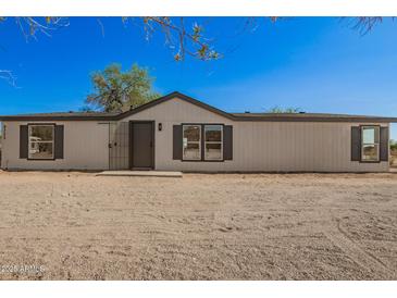 Charming single-story home with a desert landscape, neutral siding, and dark window shutters at 9735 W Altadena Dr, Casa Grande, AZ 85194