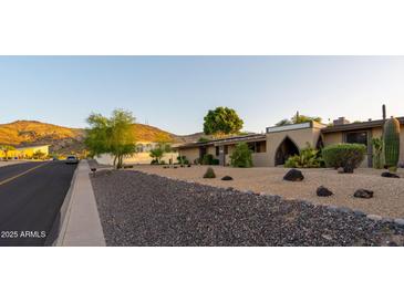 Single story home with low-water landscaping, desert plants, and an arched entryway at 13034 N 8Th Ave, Phoenix, AZ 85029