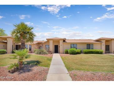 Charming single-story home with mature palm trees and well-maintained landscaping at 18416 N Spanish Garden Dr, Sun City West, AZ 85375