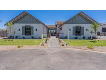 Charming single Gathering home with landscaped yard and welcoming walkway to the front door at 2095 N 77Th Pl, Mesa, AZ 85207