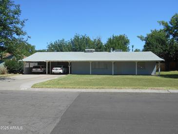 Charming single-story home with a long covered front porch and carport, nestled on a well-maintained lawn at 2818 E Elm St, Phoenix, AZ 85016