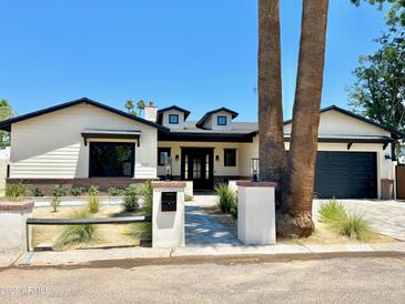 Charming home with an inviting front yard, black trimmed windows and a driveway leading to an attached garage at 3021 N 47Th St, Phoenix, AZ 85018