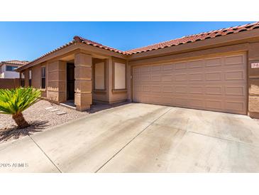 Charming single-story home featuring a terracotta roof, desert landscaping, and an attached two-car garage at 3438 S Bowman Rd, Apache Junction, AZ 85119