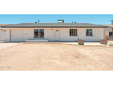 Welcoming exterior view of a single-story home featuring a freshly painted white facade and a desert landscape at 6223 W Earll Dr, Phoenix, AZ 85033