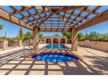 Stunning pool and spa area featuring a covered patio with wood beams and blue tile accents at 8043 E Laurel St, Mesa, AZ 85207