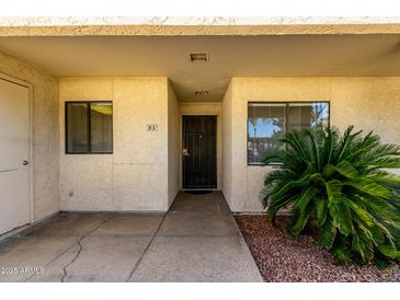 Welcoming entrance with textured walls, security door, and manicured landscaping at 11026 N 28Th Dr # 81, Phoenix, AZ 85029