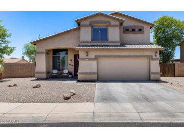 Charming two-story home showcasing a well-maintained front yard and inviting facade under a clear blue sky at 1359 E 12Th St, Casa Grande, AZ 85122