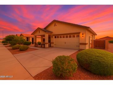 Charming single-story home featuring a two-car garage, landscaped yard, and inviting covered porch at 22403 W Harrison St, Buckeye, AZ 85326