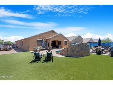 View of the backyard showcasing a well maintained yard and small pool at 37460 W Giallo Ln, Maricopa, AZ 85138