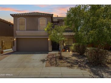 Two-story home boasts a two-car garage and desert landscaping, providing an inviting curb appeal at 43813 W Rio Lobo Dr, Maricopa, AZ 85138