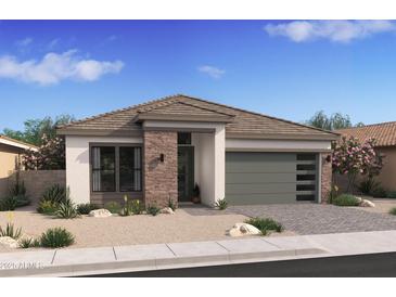Beautiful single-story home featuring stone accents, a modern garage door, and professionally landscaped front yard at 490 E Aurora Dr, San Tan Valley, AZ 85140