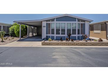 Charming blue home with a covered carport and desert landscaping adds appeal at 5735 E Mcdowell Rd # 108, Mesa, AZ 85215