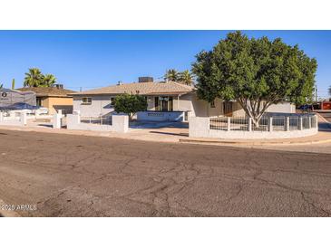 Charming single-story home featuring a low-walled front yard, mature shade tree, and inviting curb appeal at 5827 N 22Nd Dr, Phoenix, AZ 85015