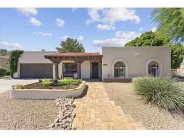 Charming home with a tile roof and well-manicured front yard, offering inviting curb appeal at 7835 E Cannon Dr, Scottsdale, AZ 85258