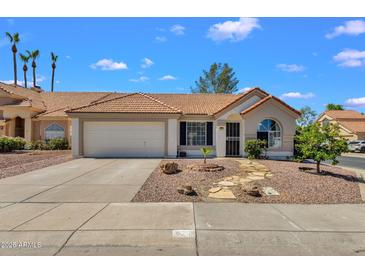 Charming single-story home showcasing a well-maintained front yard and a two-car garage at 823 W Kyle Ct, Gilbert, AZ 85233