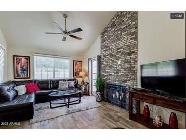 Inviting living room with vaulted ceilings and a striking brick fireplace feature wall at 1222 W Baseline Rd # 163, Tempe, AZ 85283